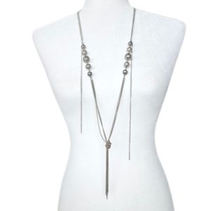 Long silver tone Y necklace with hollow filigree balls, and knot & tassel